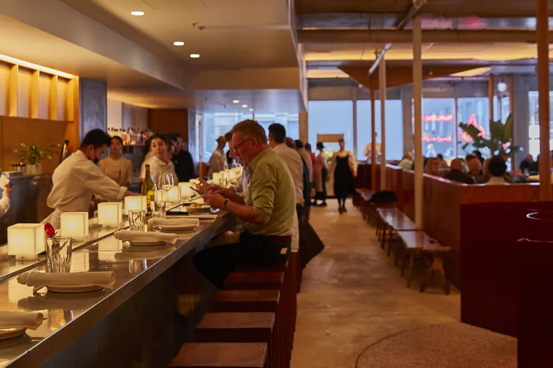 Dining room at Supernormal on Flinders Lane, booth seating and open pass.